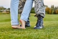 Close up soldier boots and girlfriend with naked feet. Royalty Free Stock Photo