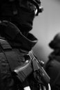 Close up soldier keeping modern gun while wearing bulletproof vest. Uniform concept.