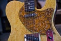 Close up of a solid natural brown electric guitar with leather pickguard