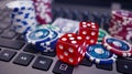 A close up of some dice and poker chips on a laptop Royalty Free Stock Photo