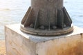Close-up: Some large steel screws and bolts enter the base of a large metal pole. The concept of industrial factory Texture