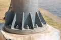 Close-up: Some large steel screws and bolts enter the base of a large metal pole. The concept of industrial factory Texture