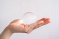 Close up of someone hand holding a clear transparent Crystal ball.