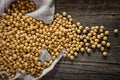 Close-up of soybean on wood background in jute sack.