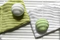 Close up spa aromatherapy composition with green bath bombs on towels.