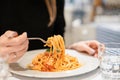 Close-up spaghetti Bolognese wind it around a fork. Parmesan cheese. Young woman eats Italian pasta with tomato, meat. Royalty Free Stock Photo