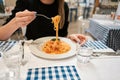 Close-up spaghetti Bolognese wind it around a fork. Parmesan cheese. Young woman eats Italian pasta with tomato, meat. Royalty Free Stock Photo