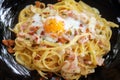 Close up of Spaghetti Carbonara with egg in white plate on the w