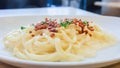 Close-up spaghetti carbonara on white dish.