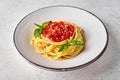 Close up spaghetti in tomato sauce, parmesan cheese and basil on white plate Royalty Free Stock Photo