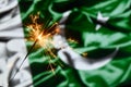 Close up of sparkler burning over Pakista flag. Holidays, celebration, party concept.