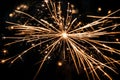 A close-up of a sparkler creating intricate patterns in the dark, illuminating the New Year