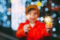 Close-up of sparklers in the hands of a boy celebrating New Year or Christmas at night on the street. The concept of Royalty Free Stock Photo