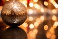 Close-Up of a Sparkling Holiday Ornament Capturing Reflections of Twinkling Lights