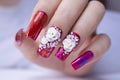 Close up sparkling red color gel polish painting beautiful 3D rose flower decorate d with shiny rhinestone and glitter on