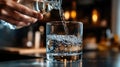 Close-up of sparkling water pouring into glass with hand in warm kitchen setting Royalty Free Stock Photo