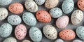 A close up of speckled easter eggs in pastel colors on a gray textured background surface Royalty Free Stock Photo