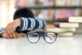 Close up spectacles. Schoolboy sleeping on books, kids tired reading for education and go to school in library Royalty Free Stock Photo