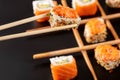 Close-up, spicy roll with tobiko caviar in chopsticks