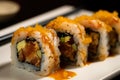 close-up of a spicy tuna roll with tempura flakes and eel sauce drizzled on top