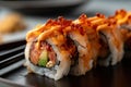 close-up of a spicy tuna roll with tempura flakes and eel sauce drizzled on top