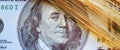 Close up spikes of wheat against US Dollar bill background. Selective focus on eyes of Benjamin Franklin. Horizontal image