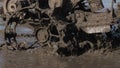 A close up of splashes of mud on a grouser of a tilling machine. Slow motion footage of a plougher equipment on a farm