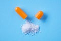 Close up split open orange medical capsule pill with spilled white powder Royalty Free Stock Photo