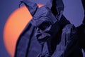 A close-up of a spooky gargoyle statue against a moonlit sky Royalty Free Stock Photo