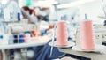 Close-up spool of multicolored threads for sewing machine. Concept Interior of garment factory