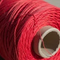A close up of a spool of red thread wrapped tightly around a cardboard core Royalty Free Stock Photo