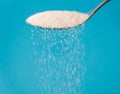 Close up of spoon pouring granulated refine white sugar