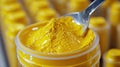 Close-up of a spoon scooping yellow powder from a container Royalty Free Stock Photo