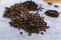 Spoonful of coffee surrounded by piles of coffee beans and star anise seeds
