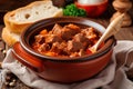 Close-up of a spoonful of traditional goulash with tender beef and paprika, served in a rustic ceramic bowl with a slice of fresh