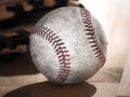 Close up sports background image of an old used weathered leather baseball laying in front of a ball glove on a wood butcher block Royalty Free Stock Photo