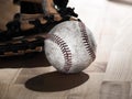 Close up sports background image of an old used weathered leather baseball laying in front of a ball glove on a wood butcher block Royalty Free Stock Photo