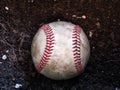 Close up sports background image of an old used weathered leather baseball laying in a pile of brown dirt showing intricate Royalty Free Stock Photo