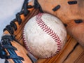 Close up sports background image of an old used weathered leather baseball with red laces inside of a baseball glove or mitt Royalty Free Stock Photo