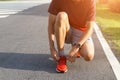 Close-up of sportsman in the tunning park He tying sneakers on running shoes before practice. Running concept Royalty Free Stock Photo