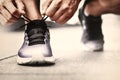 Close-up of sportsman tying sneakers. Unrecognizable man stopping lacing shoe outdoors. Athletic shoes concept. Color Version Royalty Free Stock Photo