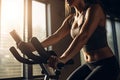 Close up of sporty young woman working out on exercise bike in gym, Woman on a fitness exercise bike at indoor, top section