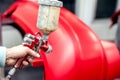 Close-up of spray gun with red paint painting a car Royalty Free Stock Photo