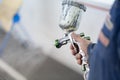 Close-up of a spray gun with white paint for painting a car in a special booth Royalty Free Stock Photo