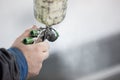 Close-up of a spray gun with white paint for painting a car in a special booth Royalty Free Stock Photo