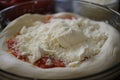 close-up of spreadable cheese on pizza dough, ready to be baked