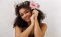Close up spring portrait of gorgeous smiling african-american young woman with fresh pink rose flower in curly hair Royalty Free Stock Photo