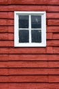 Close up square white window inred wooden barn.