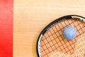 Close up of a squash racket and ball on the wooden background