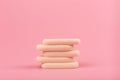 Close up of stack of beige make up sponges on pink background with copy space
